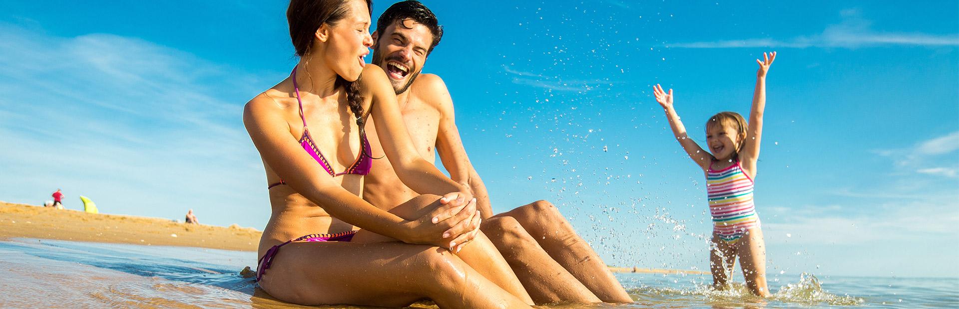 Famille au bord de l'eau à la plage